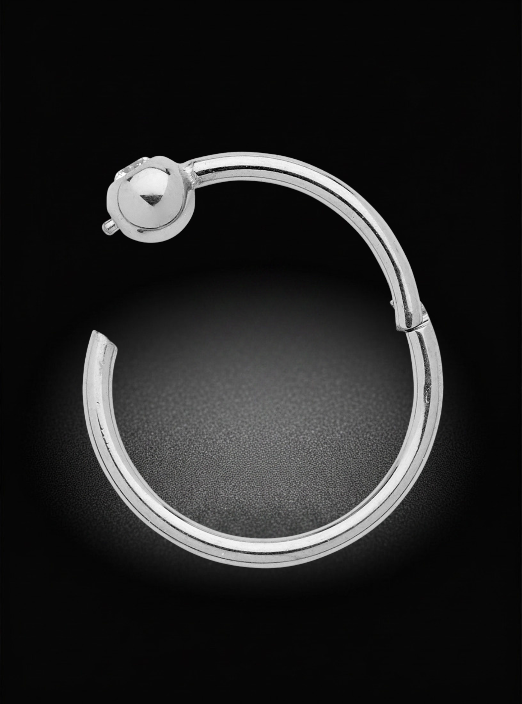 A polished silver-toned hoop earring with a small ball stud closure, shown against a dark black background.