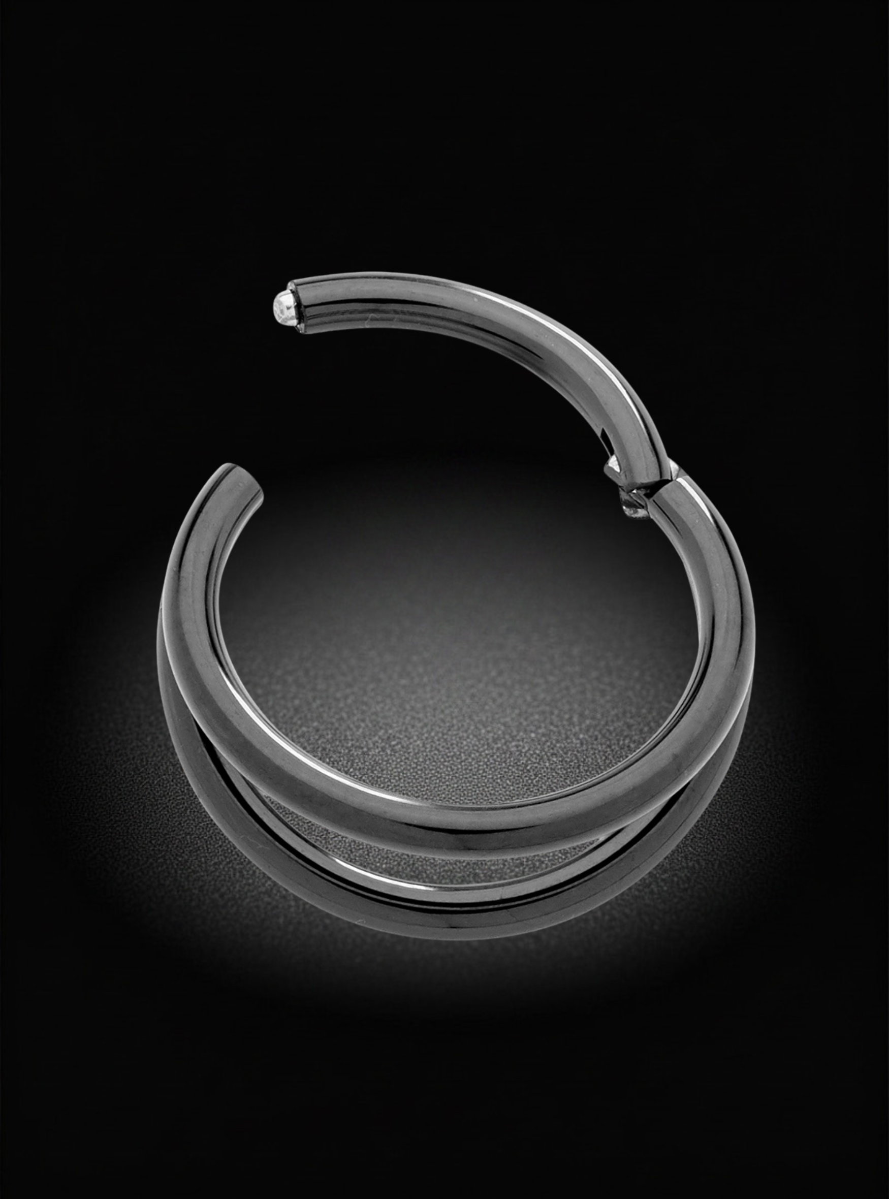 A polished silver-tone metal hoop earring with a small flat bar extending from the top, displayed on a dark reflective surface against a black background.