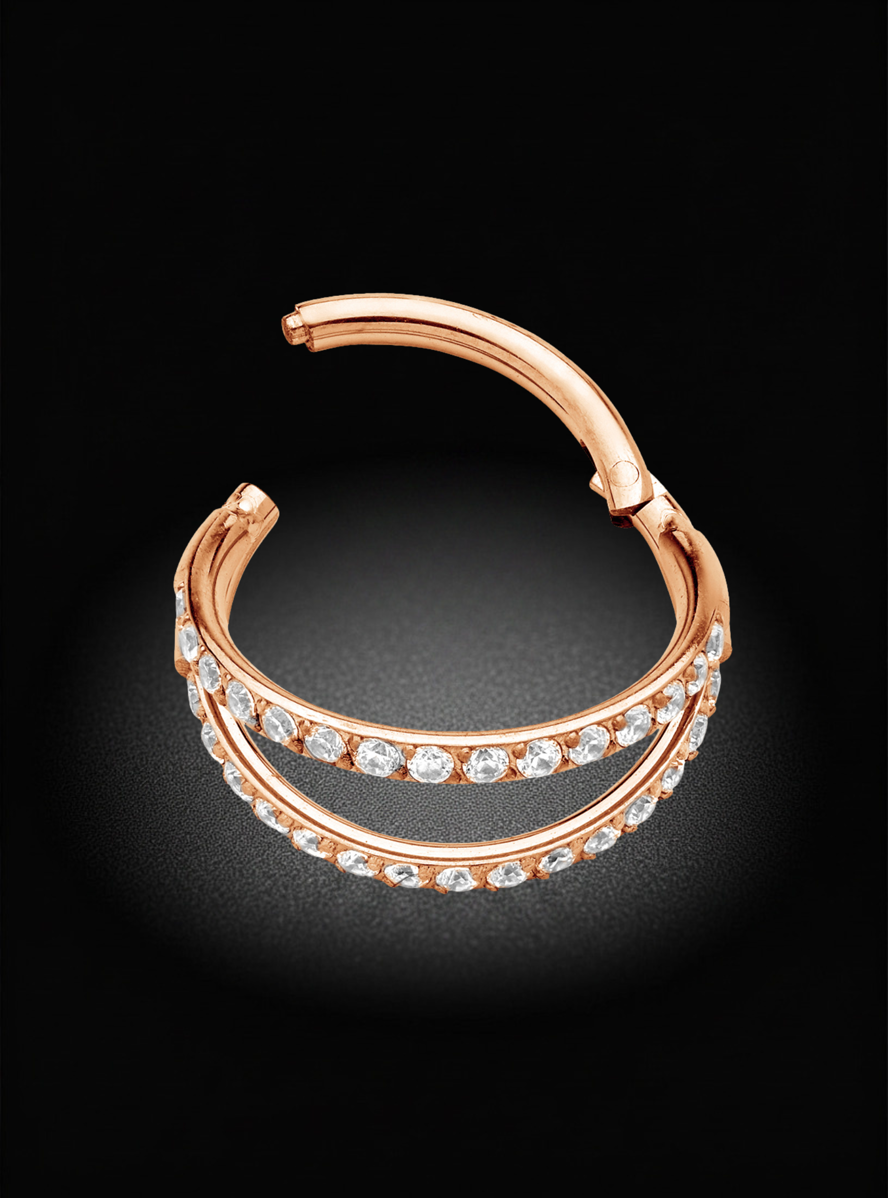 A rose gold huggie hoop earring with two rows of pavé-set round diamonds, displayed on a dark black background.