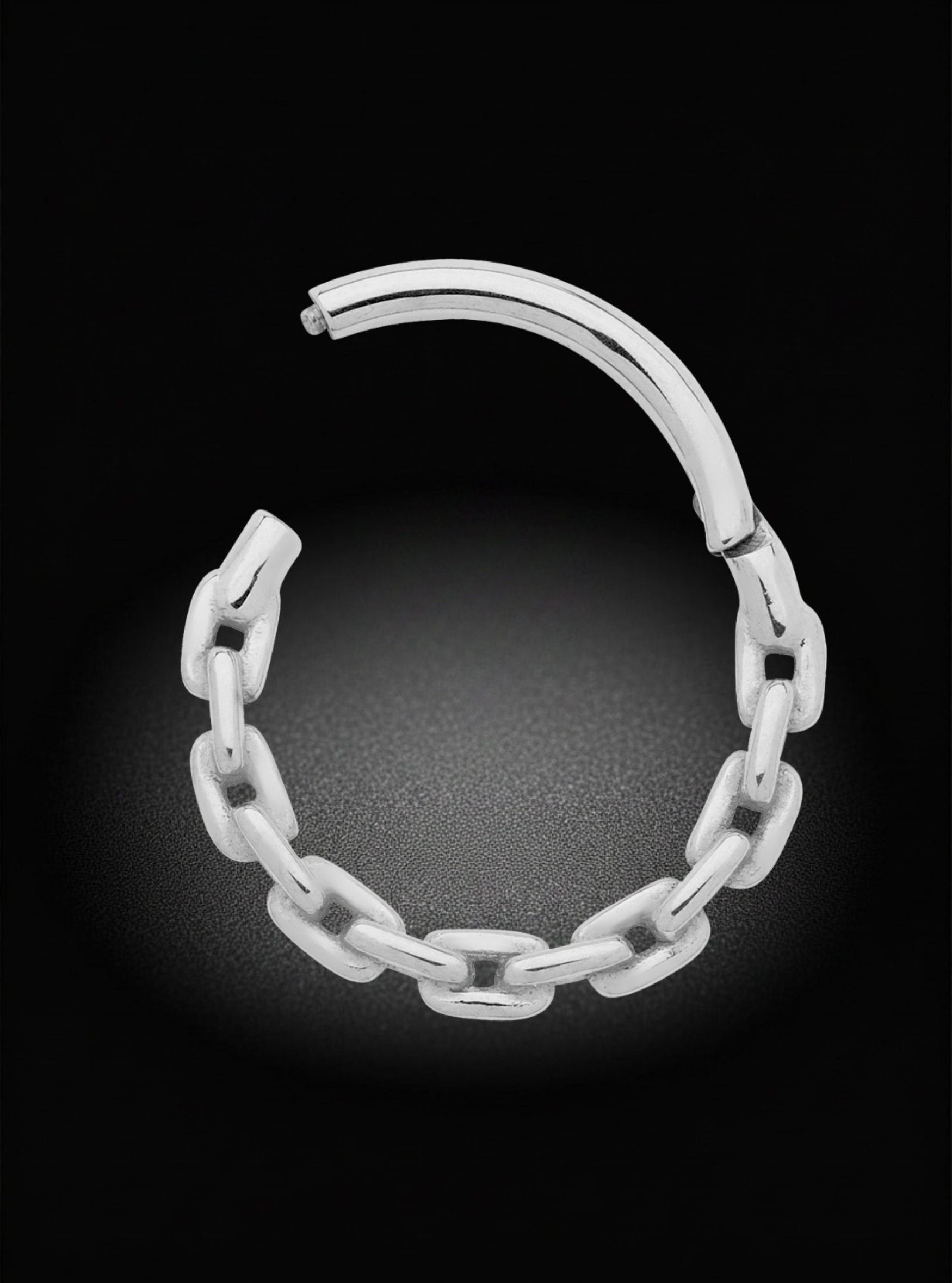 A polished silver-toned chain-link hoop earring shown on a black background with a soft glow beneath it.