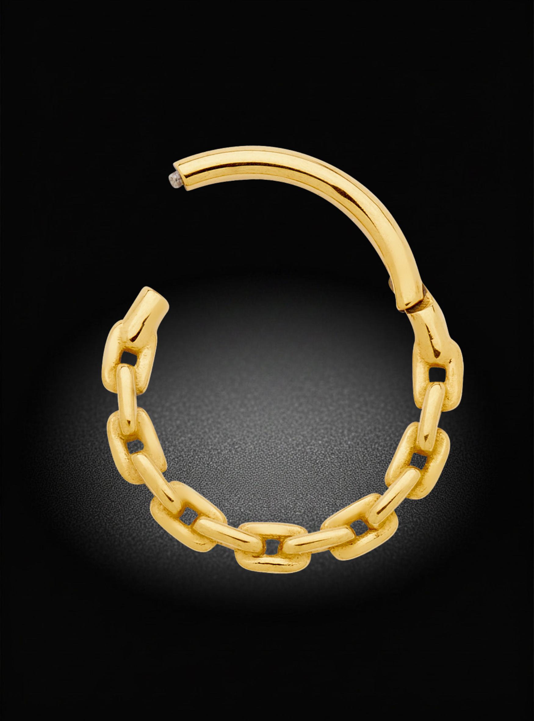 A gold huggie hoop earring with a thick, polished chain-link design and a spring-ring clasp, shown on a dark black background.