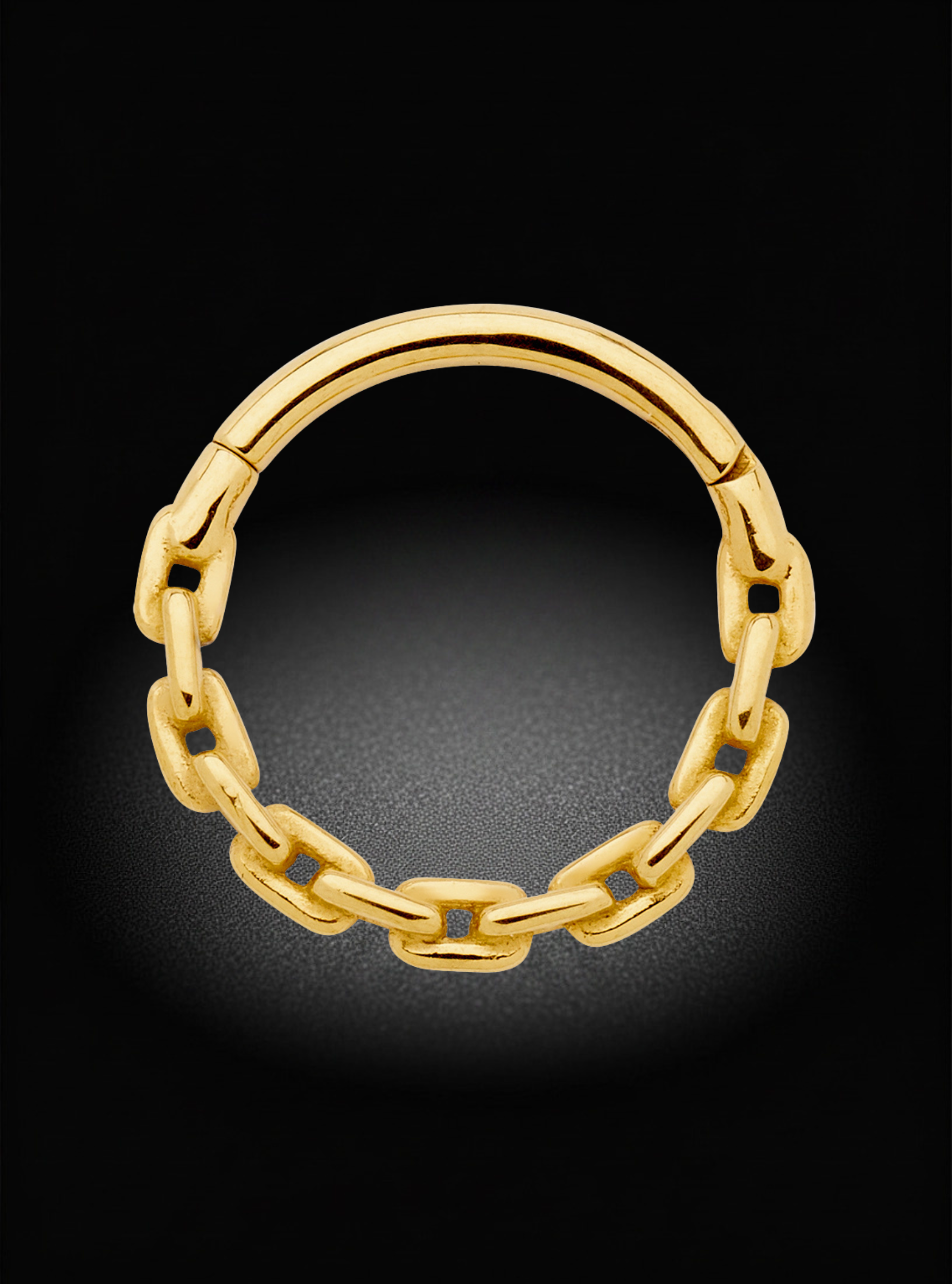 A gold chain-link hoop earring with a polished finish, displayed against a dark black background with a soft spotlight effect.