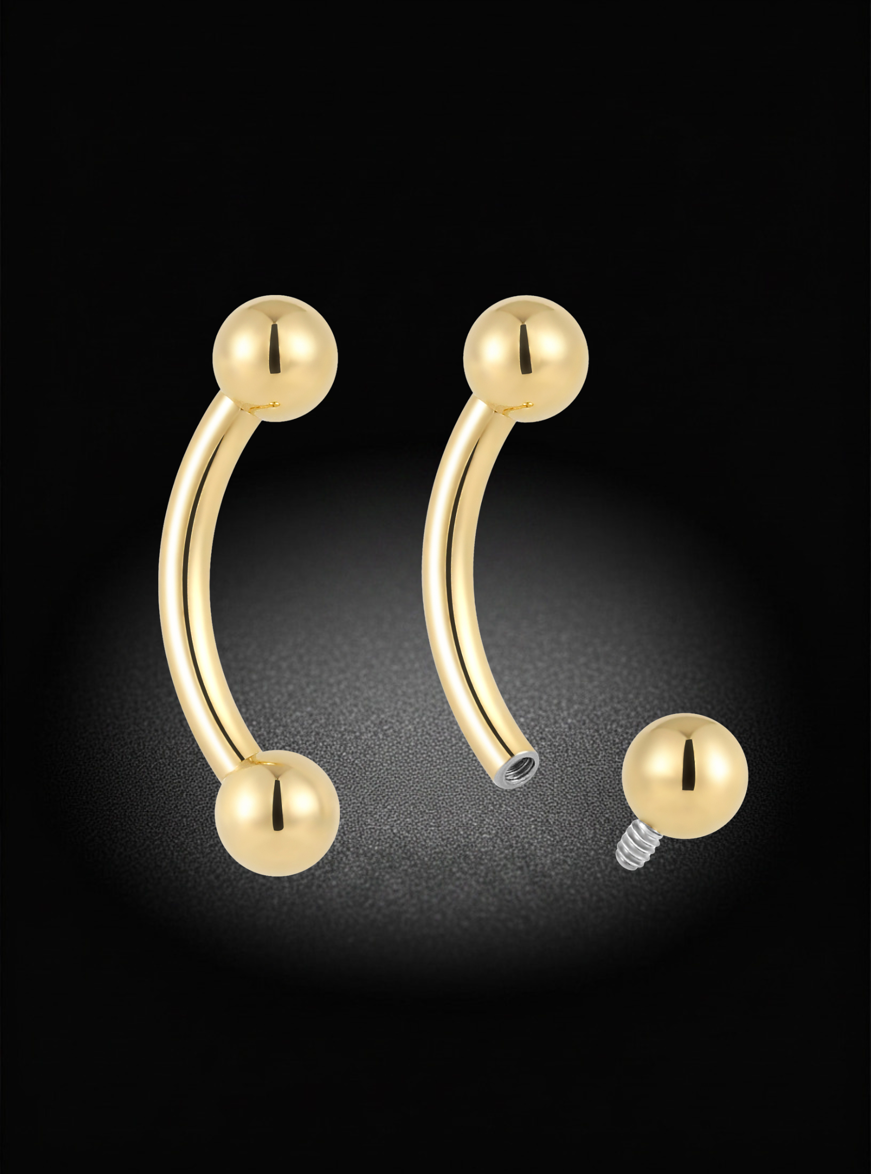 Gold-plated curved barbell piercing earrings with spherical ball ends, shown on a black background with one earring displayed front-facing and another angled to show the screw-back closure.