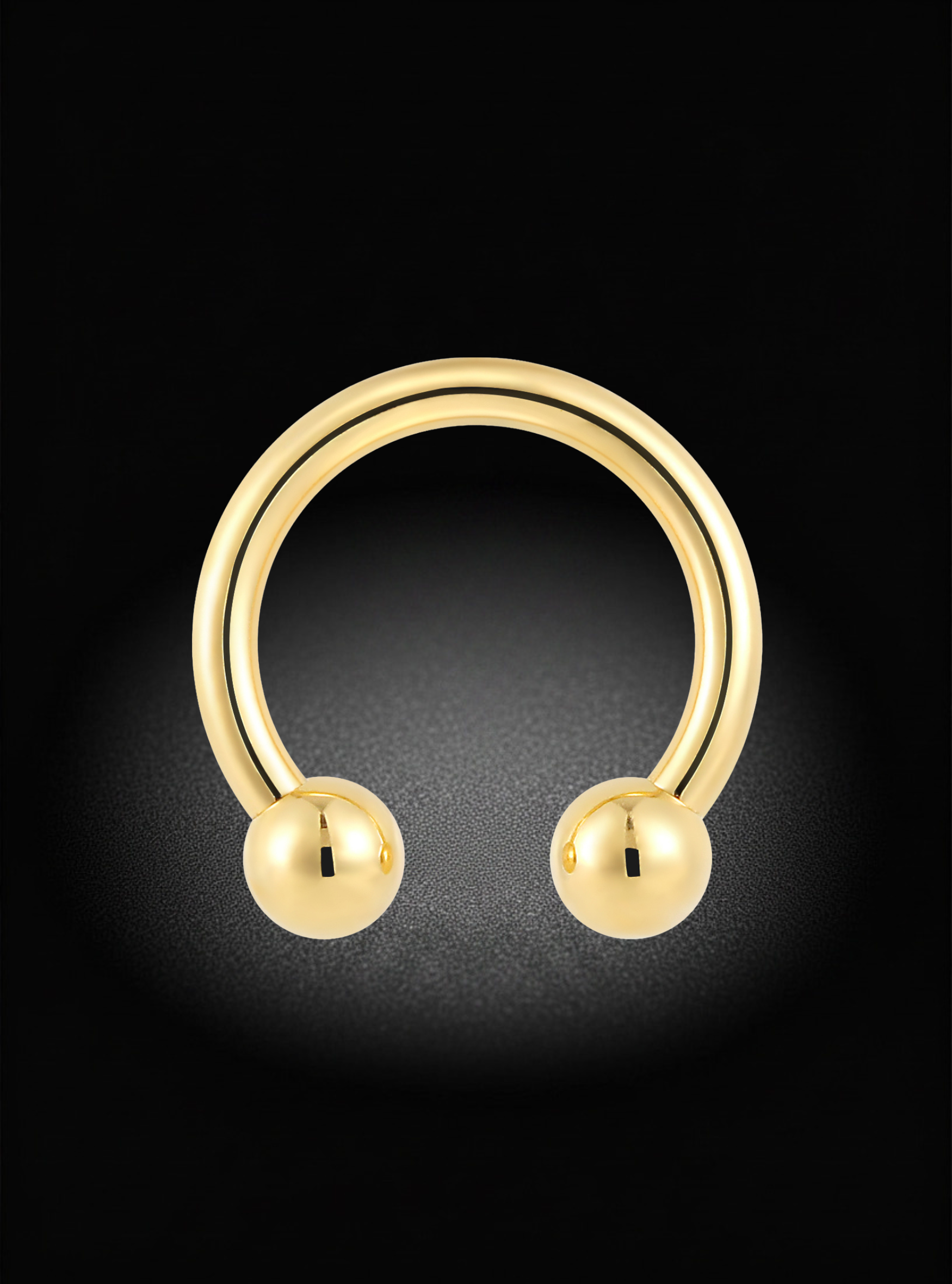 A polished gold hoop-style body jewelry piece with rounded ball ends, centered on a black background with a soft glow.