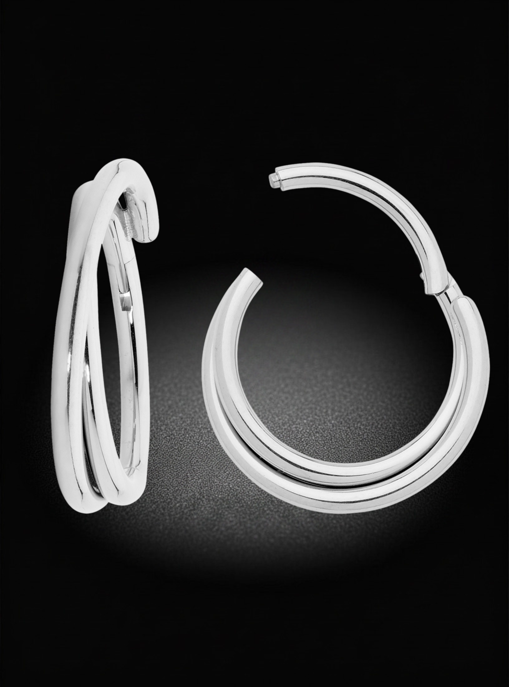 A pair of polished silver hoop earrings displayed on a black background, one showing the front view and the other the side profile.