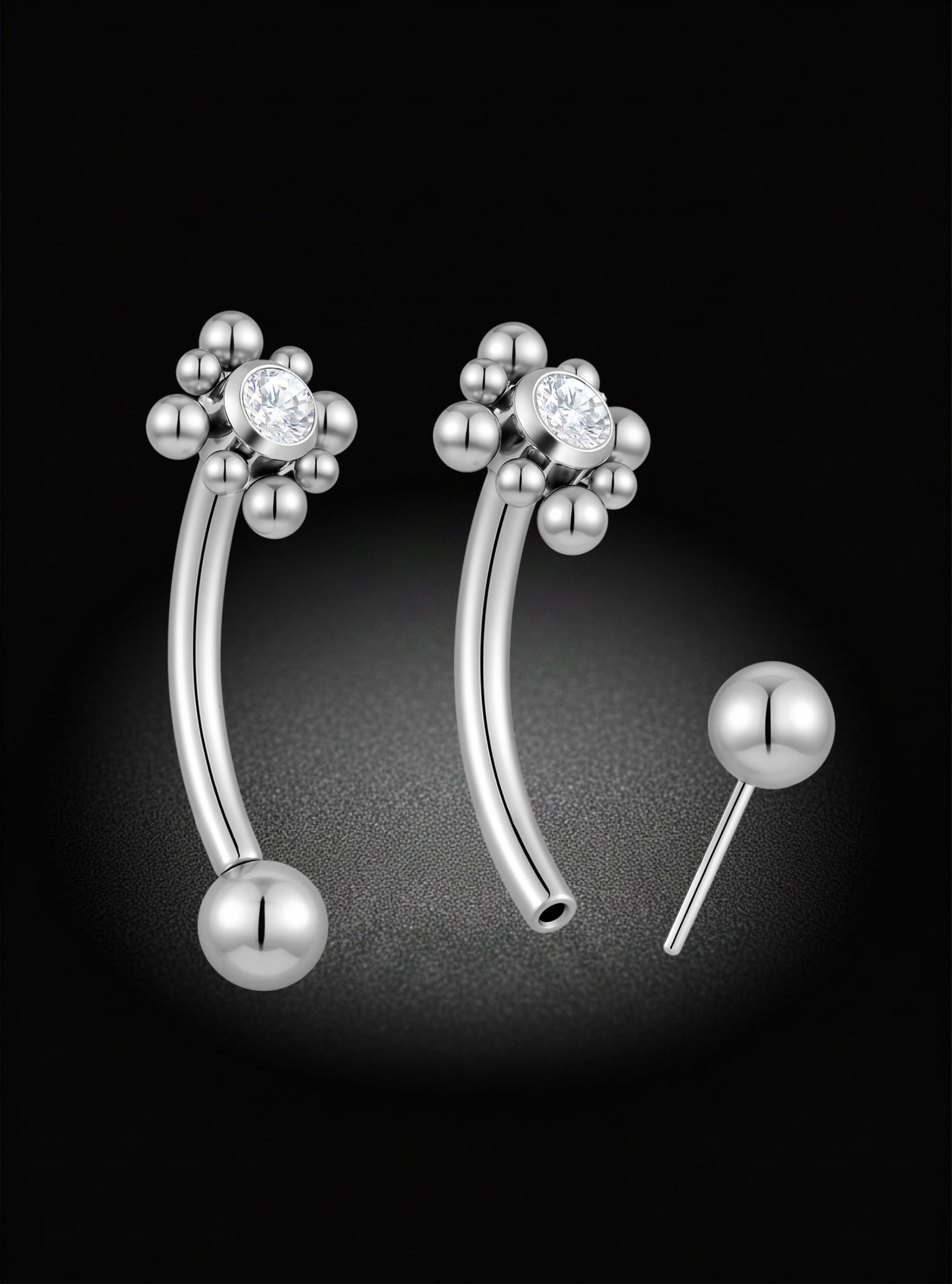 Silver curved barbell eyebrow barbells with a flower-like cluster of small beads and a clear central stone, shown on a black background with one earring front view and the post shown separately.