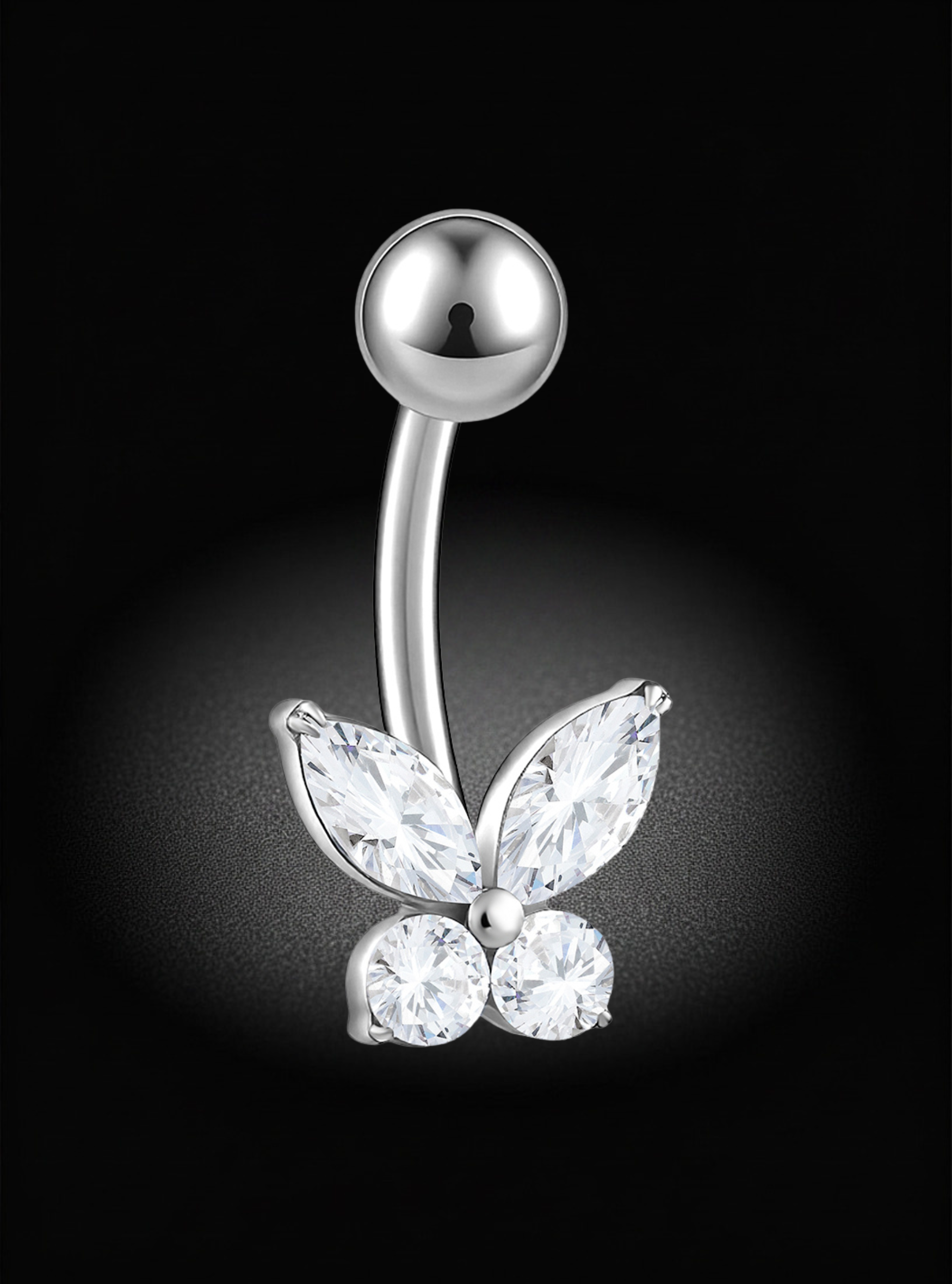 A silver-toned curved barbell belly button ring featuring a butterfly design with marquise-cut and round clear gemstones, shown against a black background with a soft spotlight effect.