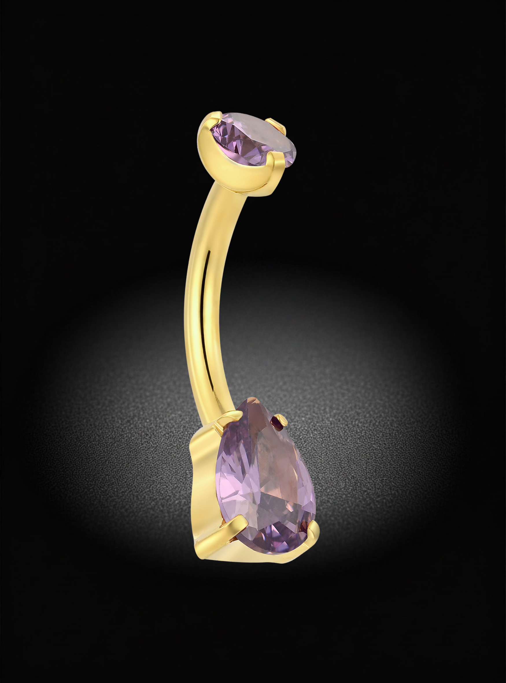 A curved gold barbell belly button ring featuring two teardrop-cut light purple gemstones, set against a dark background with a soft spotlight effect.