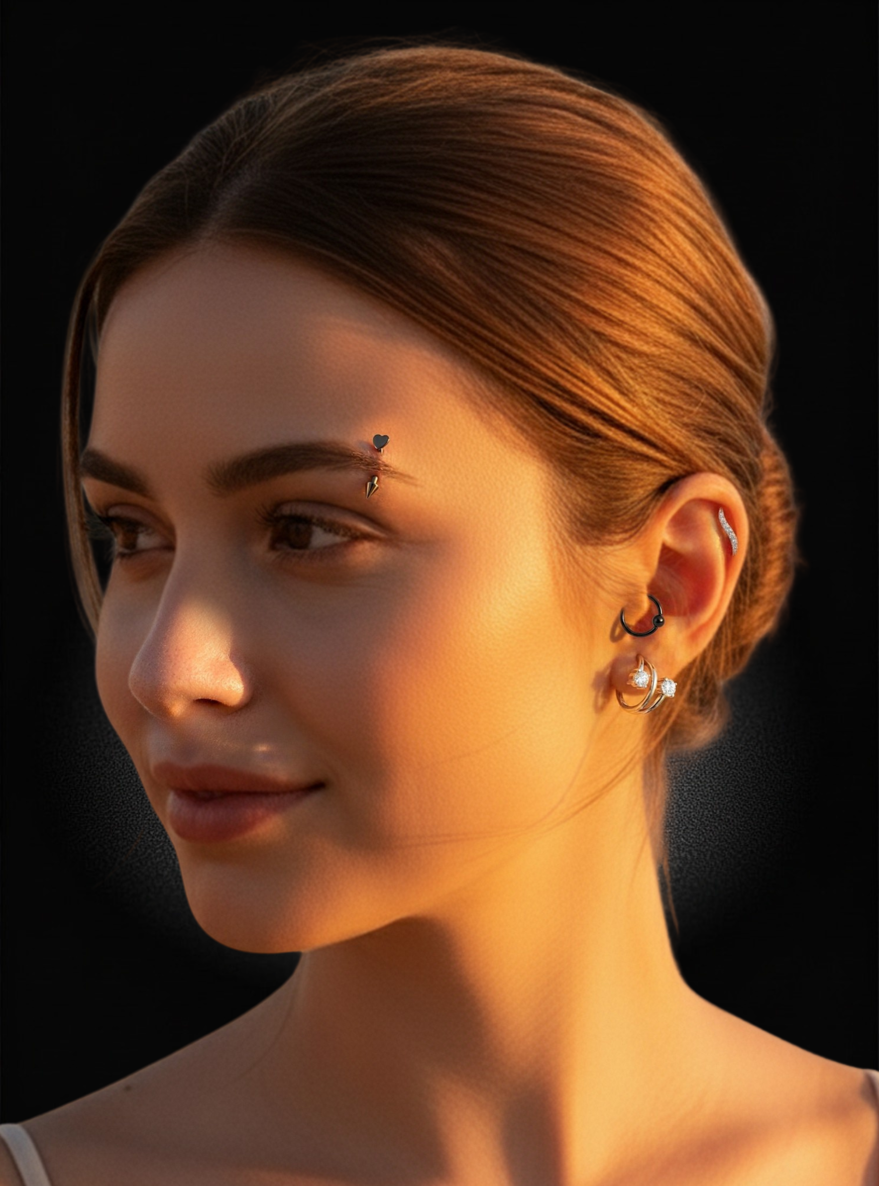 Close-up portrait of a woman with warm golden lighting against a black background, wearing small hoop and stud earrings with a tiny forehead jewelry piece.
