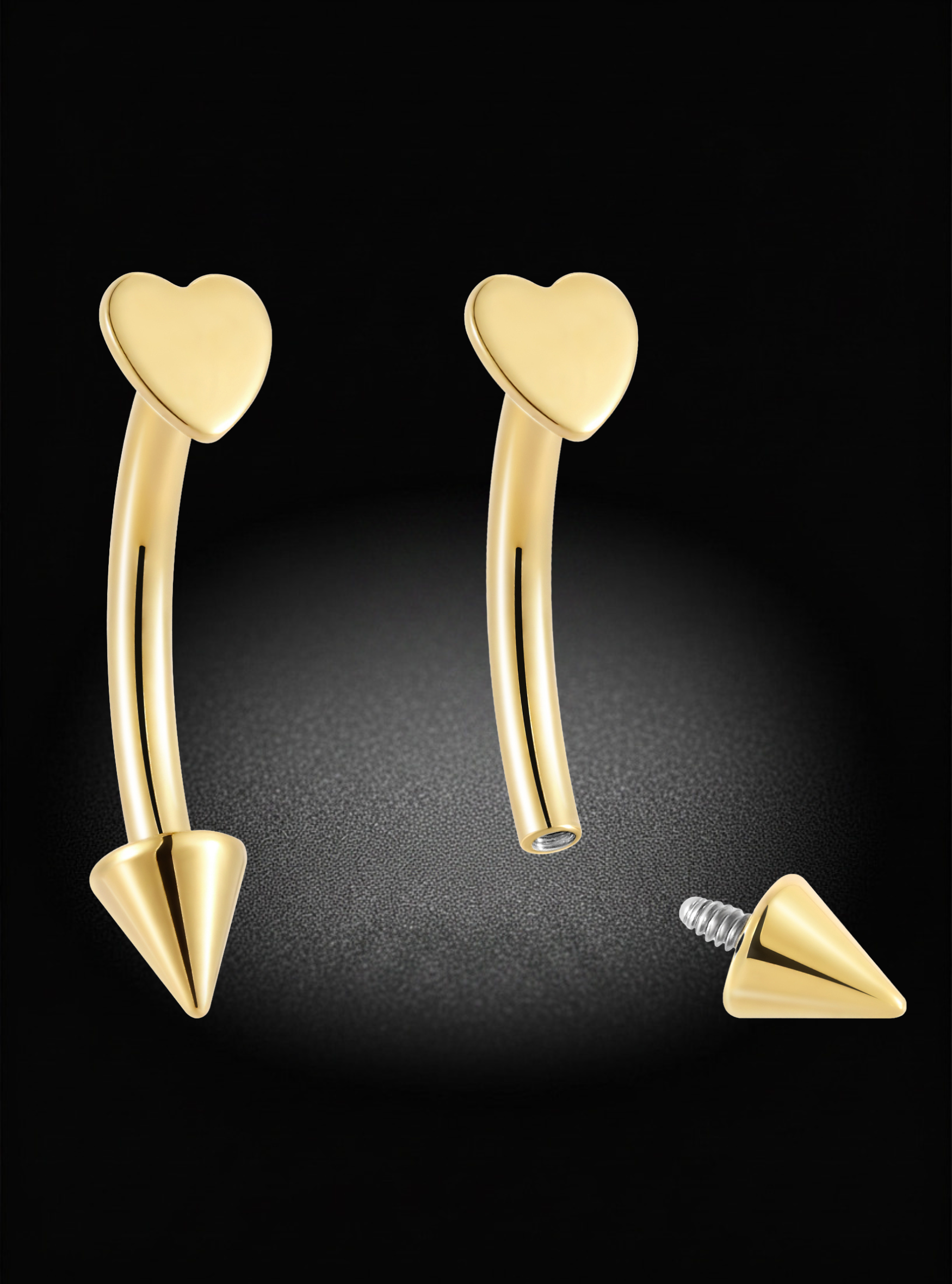Gold curved barbell lip ring piercing jewelry with heart-shaped tops and cone-shaped bottom spikes, shown on a black background with one piece reversed to display the screw-back end.