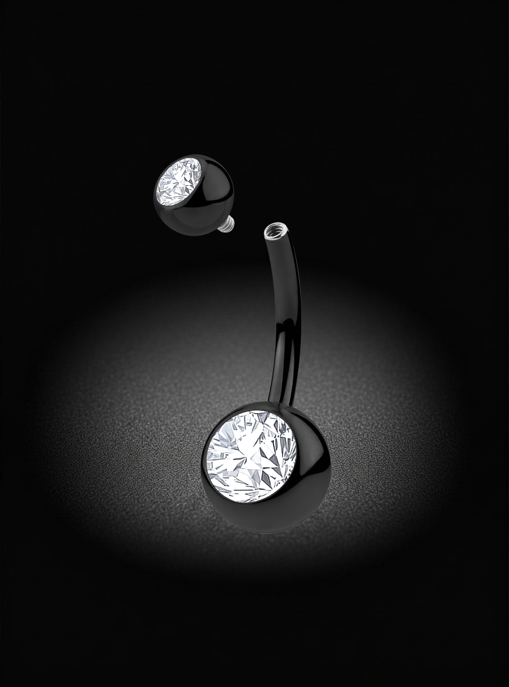 A curved barbell belly button ring with a large round clear gemstone and a smaller round clear gemstone on a black background.