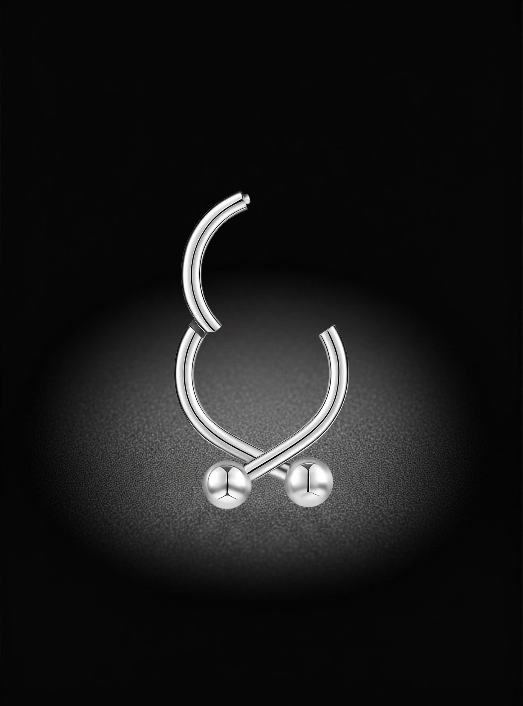 A silver-toned curved barbell-style body jewelry piece with two small round bead ends, centered on a black background with a soft spotlight effect.