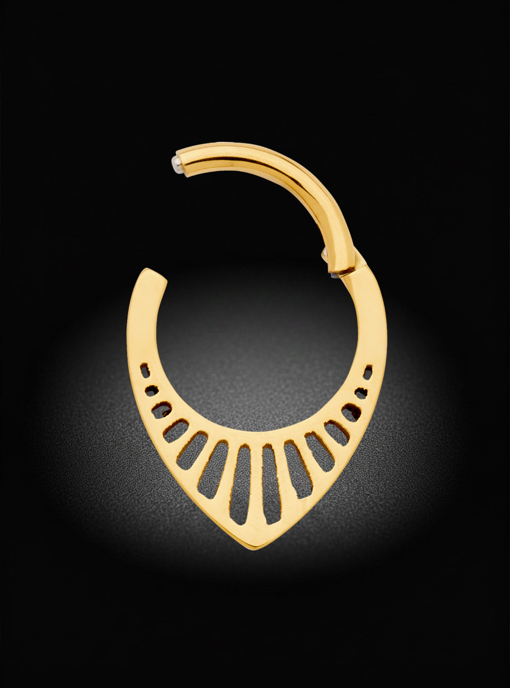 A gold crescent-shaped hoop earring with a fan-like cutout design, displayed on a dark background with a soft spotlight effect.