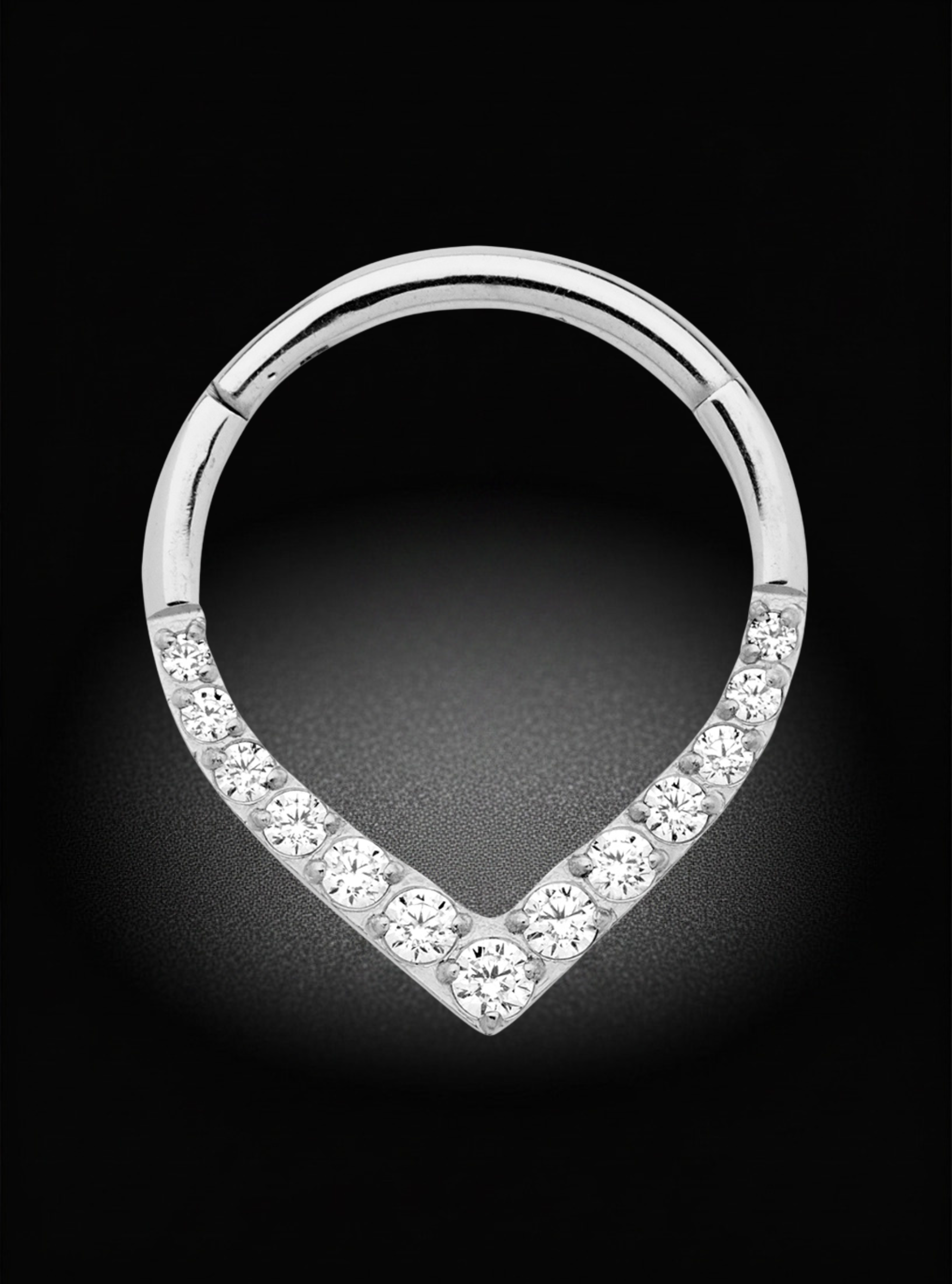 A silver-toned huggie hoop piercing ring decorated with clear pavé-set round cubic zirconia stones along the lower half, shown on a black background.