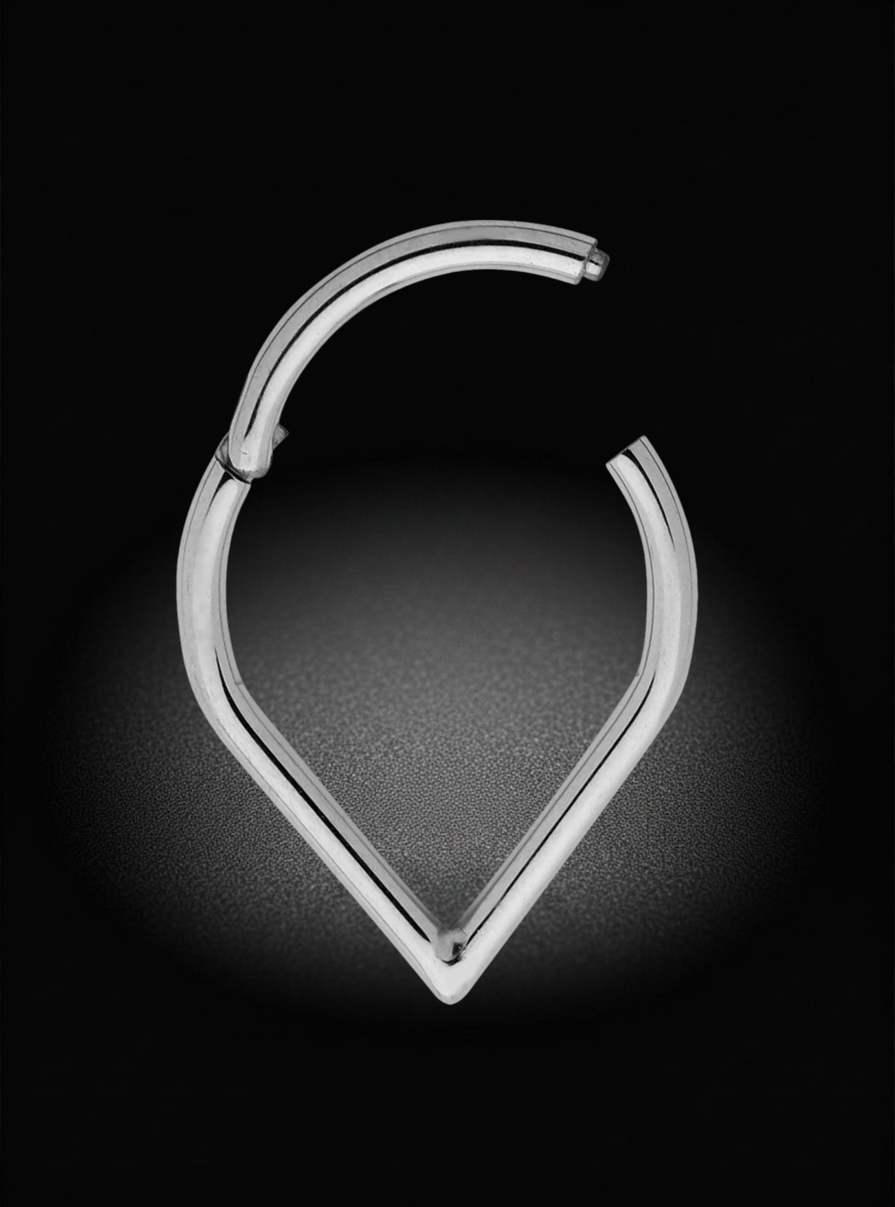 A polished silver-toned metal hoop earring with a unique open, curved design, displayed on a dark textured background with a soft spotlight effect.