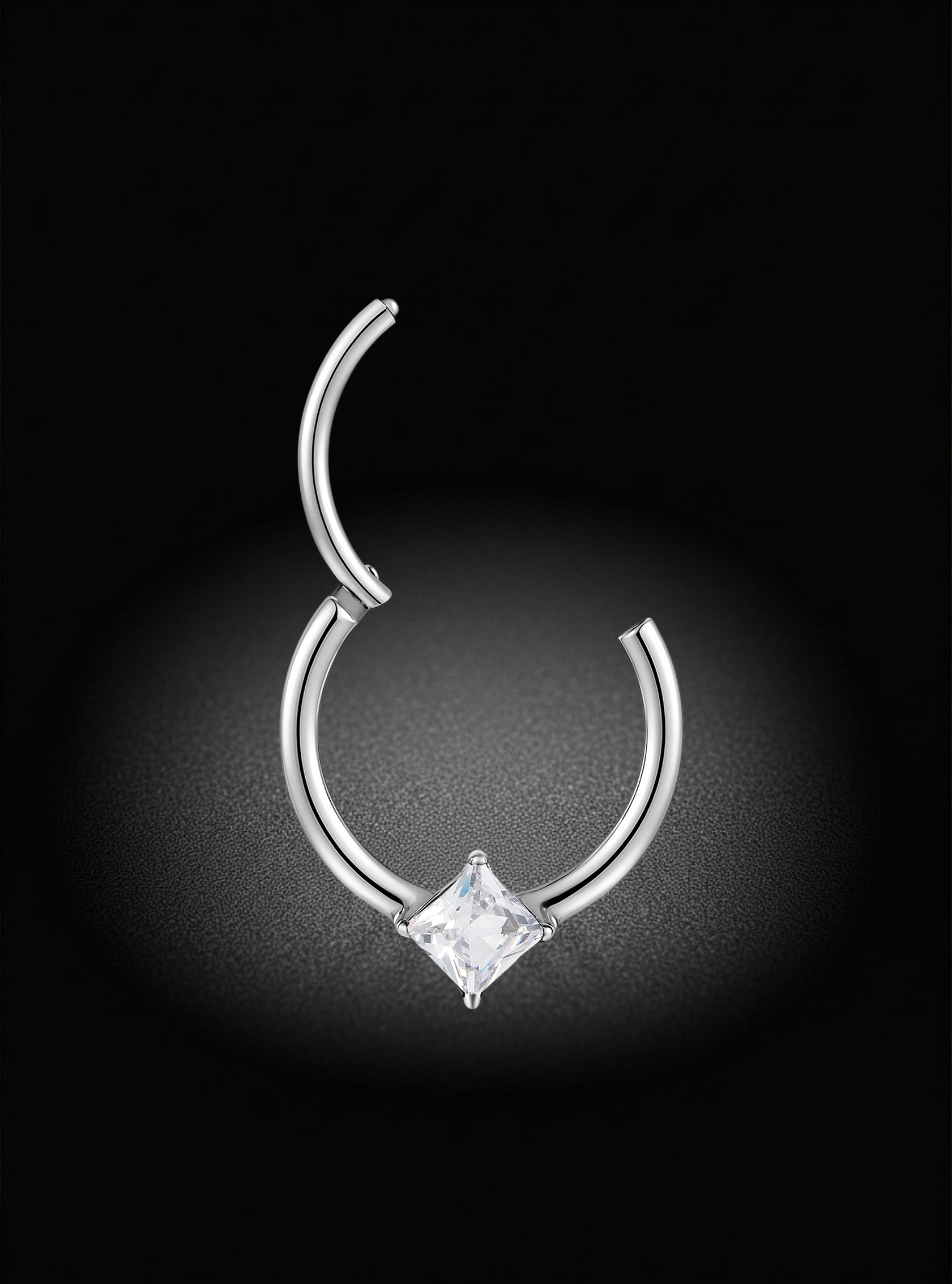 A silver-toned curved hoop piercing stud with a clear square gemstone at the center, shown against a dark black background with a soft spotlight effect.