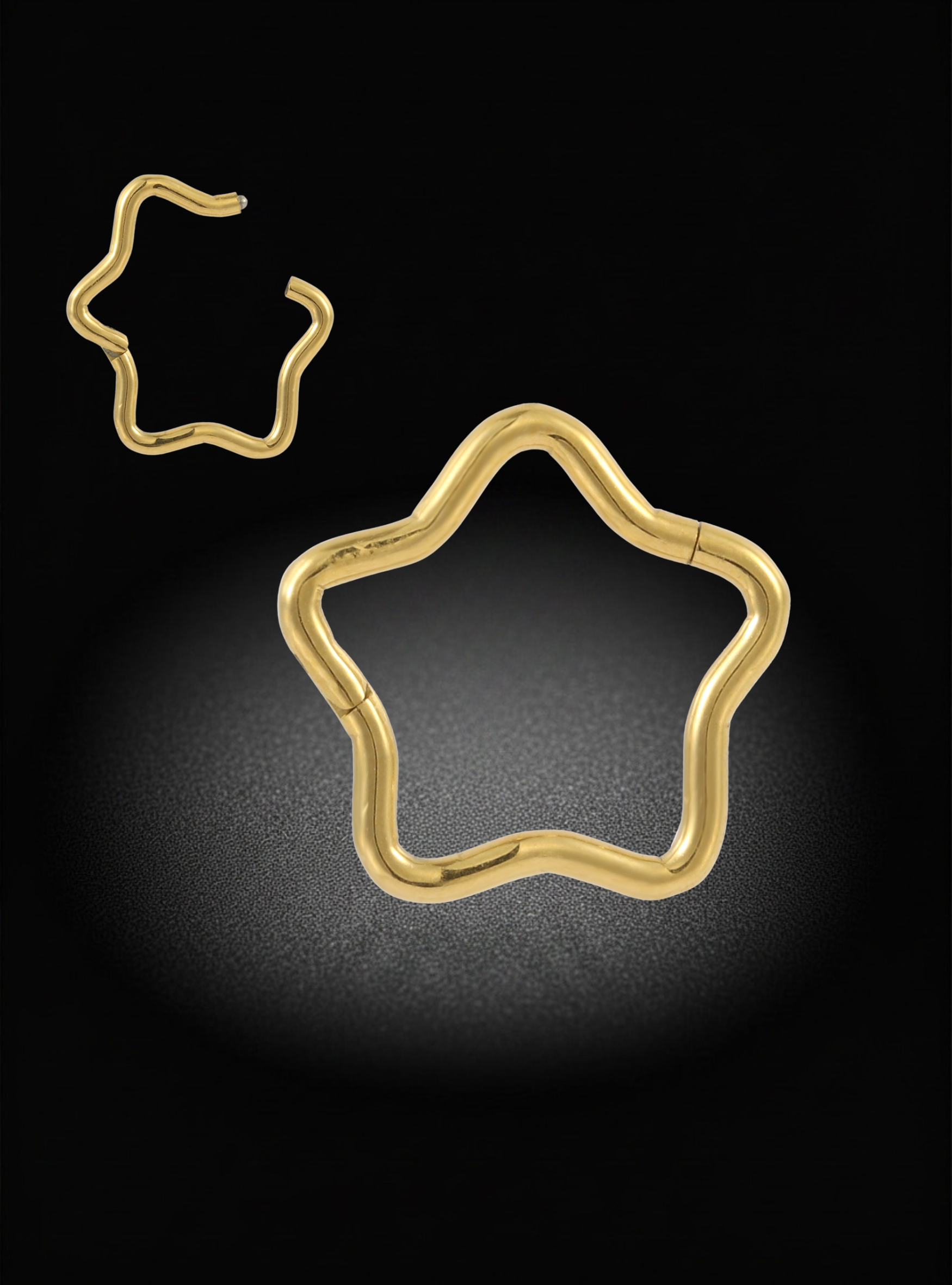 Two gold-toned star-shaped hoop earrings displayed on a black background, with one larger earring centered below a smaller one in the upper left.