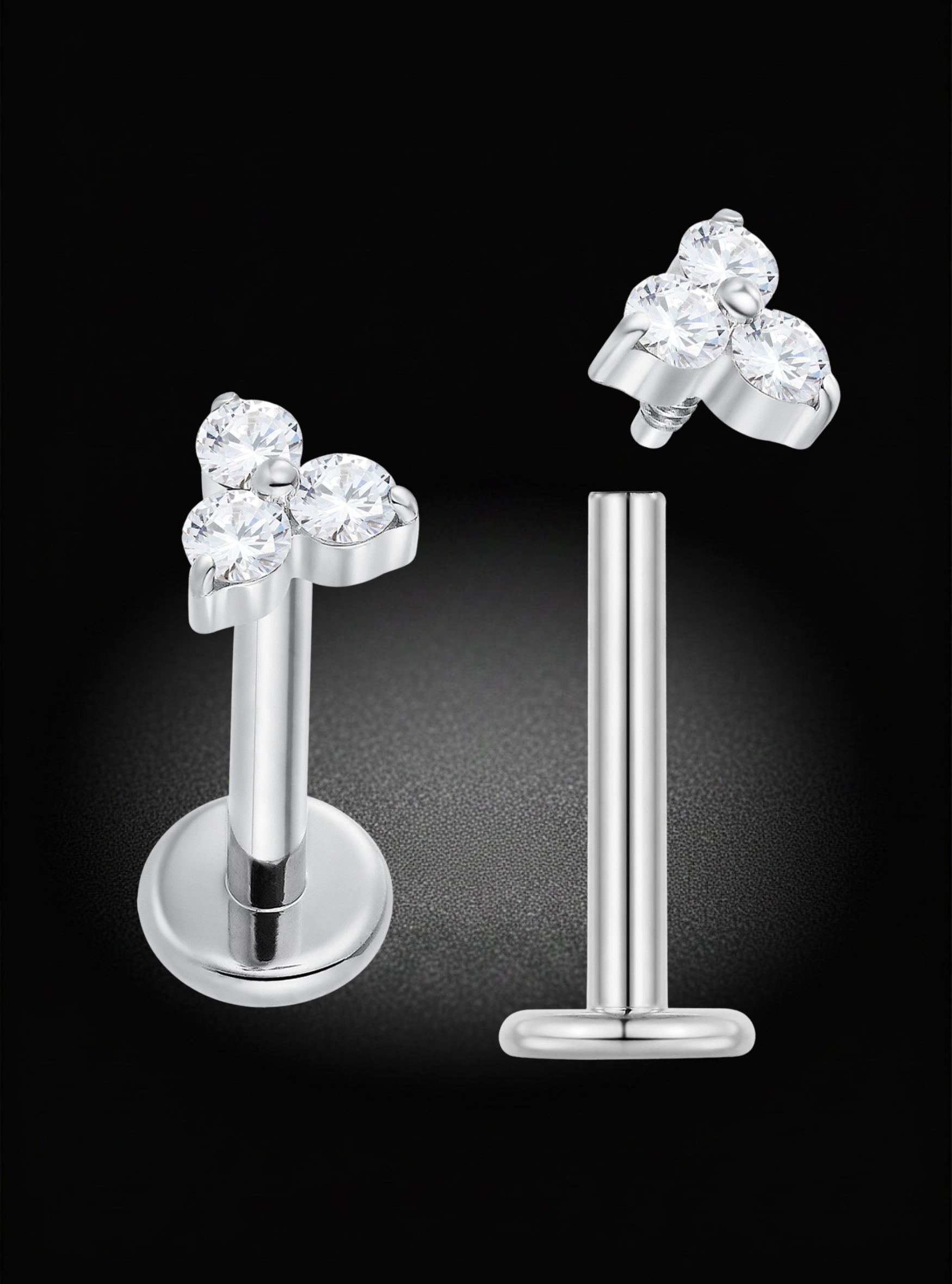 Silver-toned labret stud earrings with a cluster of three clear round-cut gemstones on the top, shown from front and side angles against a black background.