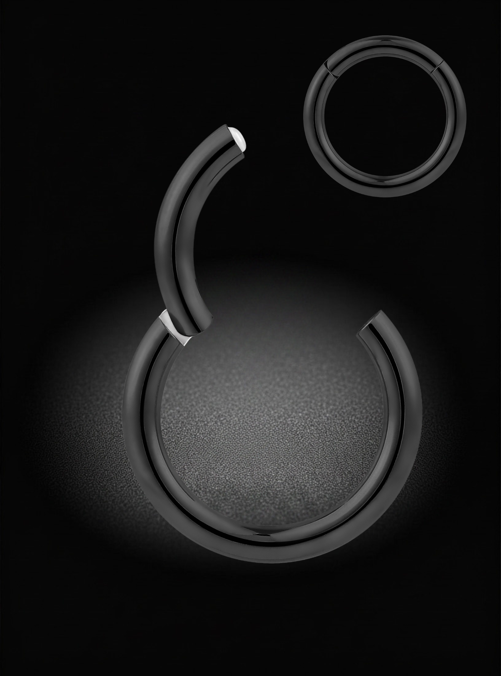 Black Hinged segment ring earring curved ring arranged on a black background, with one larger piece in the center and two smaller pieces near the top.